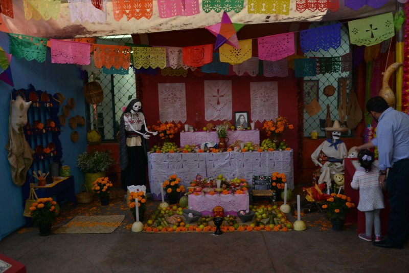 Un padre muestra a su hija los llamados altares de la muerte en el museo de la cultura en Coayacán